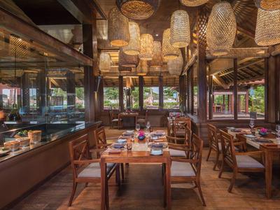 Gemütliches Restaurant mit Holzmöbeln und Hängelaternen in warmem Licht.