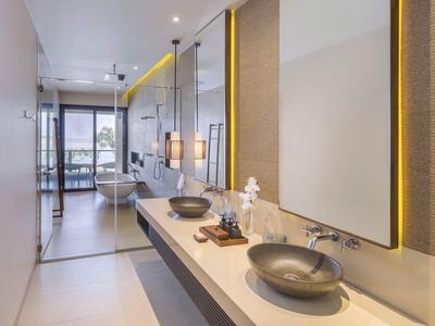 Moderne Hotellbadezimmer mit zwei Waschbecken und indirekter Beleuchtung an den Spiegeln.