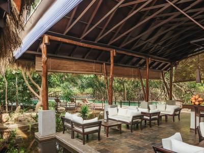 Zastřešená terasa s posezením a výhledem na zahradu.