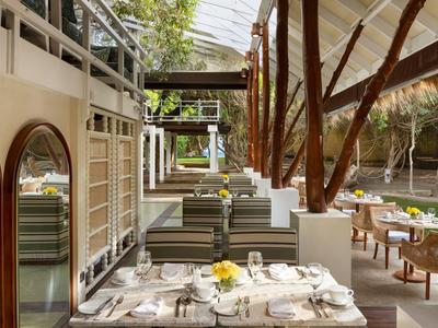 Ristorante elegante e moderno con tavoli apparecchiati e molta luce naturale grazie al tetto di vetro.