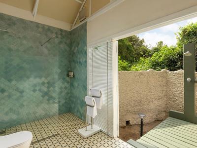 Moderní koupelna s velkou skleněnou stěnou s výhledem na zahradu