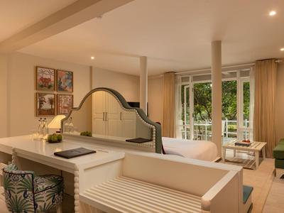 Moderní obývací pokoj s otevřenou kuchyní, sezením a výhledem na balkon.