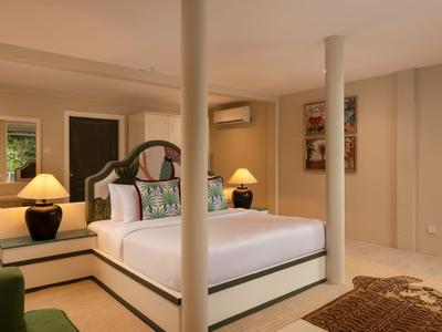 Pohodlná ložnice s velkou postelí, dvěma nočními stolky a teplým osvětlením.