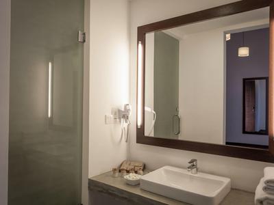 Nowoczesna łazienka z dużym lustrem, umywalką i ścianką prysznicową.