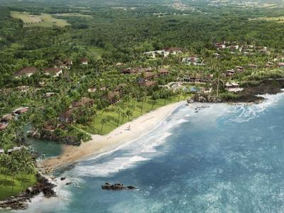 Überblick über eine Küstenstadt mit Strand, Gebäuden und viel Grünfläche.