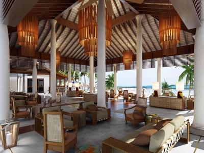 Große offene Lounge mit Holzdecke, Sitzgruppen und Blick auf das Meer.