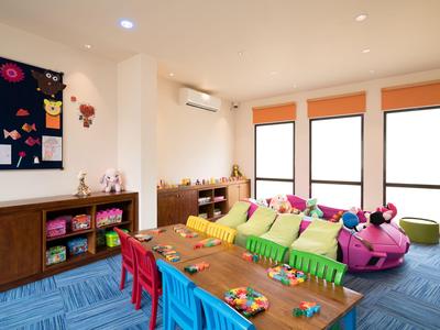 Bunter Kinderspielraum mit Tischen, kleinen Stühlen, Sofas und bunten Spielsachen.