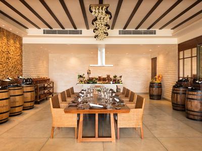 Elegantes Restaurant mit Holztischen, Stühlen und Weinfässern als Dekoration.