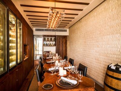 Eleganter Esstisch in einem Restaurant mit Weinkühlern und Weinfass.