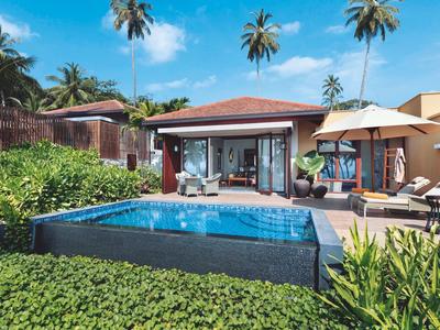 Moderner Bungalow mit privatem Pool und tropischem Garten bei sonnigem Himmel.