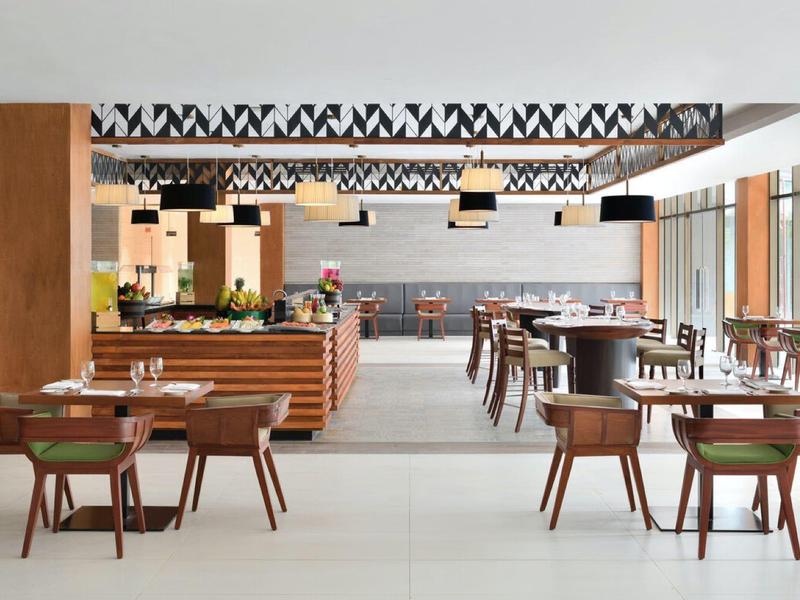 Ampia sala da pranzo moderna e luminosa con mobili in legno e ampie finestre.