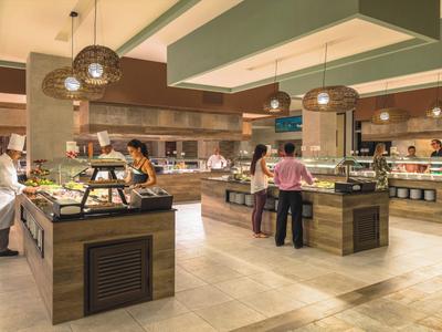 Area buffet in un hotel con più postazioni di cibo e ospiti.