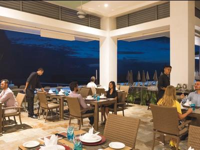Terrazza ristorante dell'hotel di sera con clienti che mangiano e camerieri al lavoro.