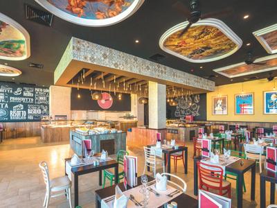 Ristorante moderno con soffitto decorato e tavoli apparecchiati.