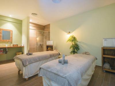 Sala massaggi con due lettini, asciugamani e decorazioni rilassanti.