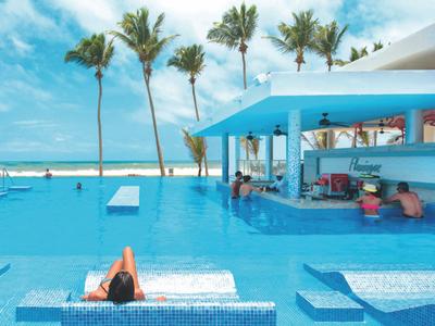 Pool bar dell'hotel con grandi piscine, palme e cielo azzurro in una giornata di sole