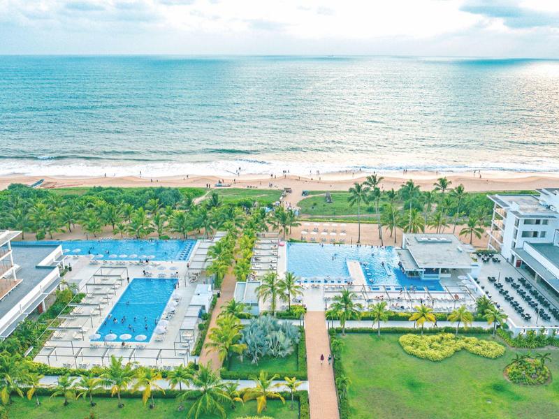 Complesso hotel con piscine, aree verdi e vista sulla spiaggia e sul mare.