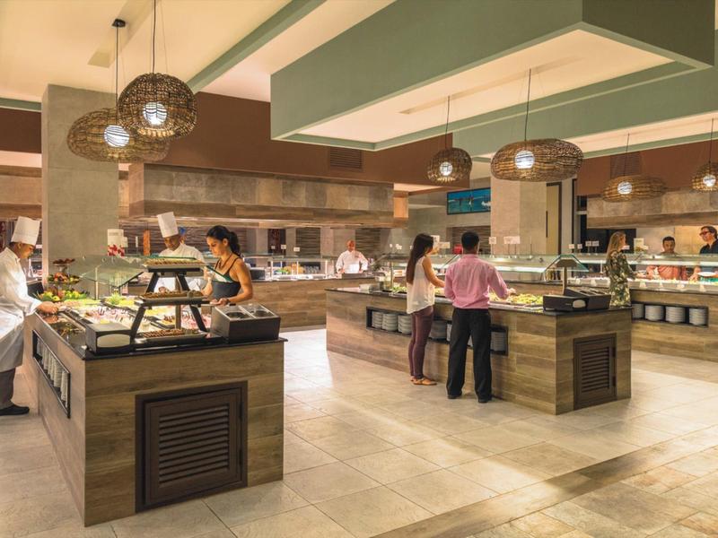 Buffet moderno in un ampio spazio ristorativo di un hotel con diverse isole e clienti.