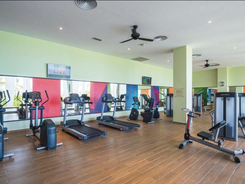 Ampia palestra con molte attrezzature moderne e pavimento in legno.