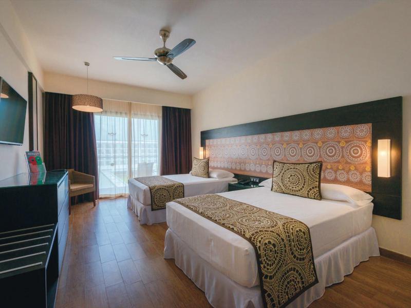 Camera moderna con due letti, decorazione elegante e balcone luminoso.