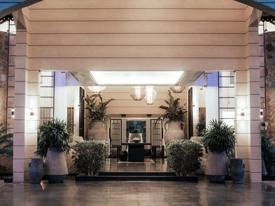 Moderner Hotelfoyer-Eingang mit großen Pflanzen und hellen Wänden.