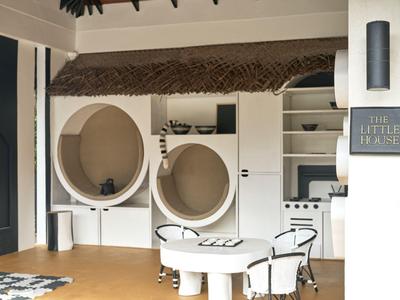 Moderner Hotel-Empfangsbereich mit rundem Stuhl und kleinem Tisch in hellen Farben