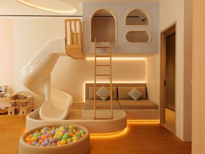 Moderne hotel speelruimte met glijbaan, klimladder en ballenbak in warme houttinten.