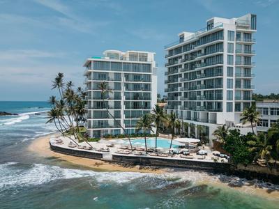Modern hotel aan zee met zwembad op een schiereiland en palmbomen