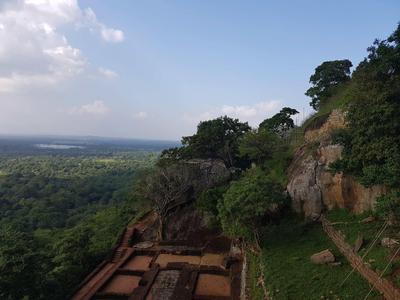 Vue sur un paysage boisé avec des rochers et des ruines anciennes sur une colline
