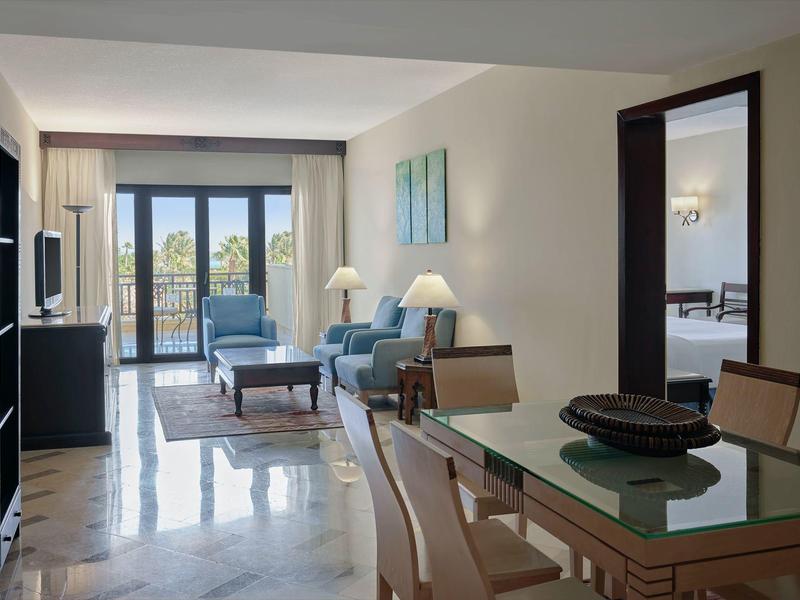 Salon lumineux avec table en verre, canapé et balcon avec vue sur la mer