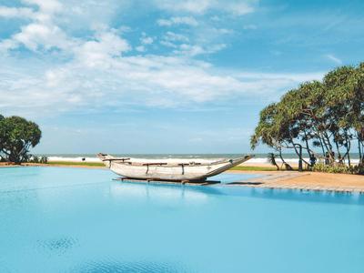 Ein Boot schwimmt in einem klaren Pool mit Bäumen und Himmel im Hintergrund.
