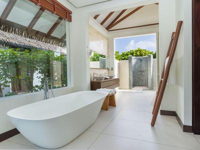 Modernes Badezimmer mit freistehender Badewanne und großem Fenster mit Blick auf den Außenbereich.