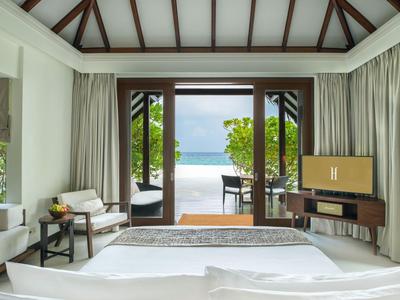 Helle Hotelzimmer mit offenem Zugang zur Terrasse und Blick auf das Meer.
