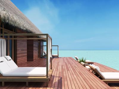 Luxuriöse Überwasser-Bungalows mit Liegestühlen und direktem Meerblick unter klarem Himmel.