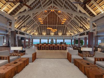 Luxuriöse Hotel-Lounge mit Holzdecke, bequemen Stühlen und Blick aufs Meer.