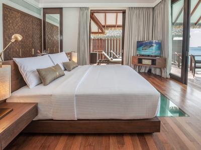 Modernes Hotelzimmer mit großem Bett, Holzfußboden und Balkon mit Meerblick