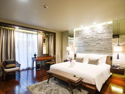 Modernes Hotelzimmer mit gemütlichem Doppelbett, Schreibtisch und Sesseln.