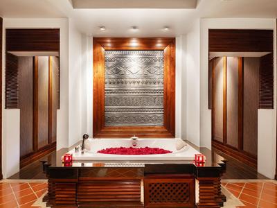 Luxuriöse Badewanne mit Rosenblättern in elegant gestaltetem Badezimmer.