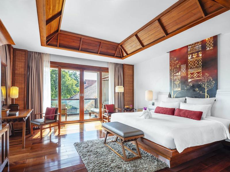 Modern eingerichtetes Hotelzimmer mit Doppelbett, Holzboden und Balkon mit Aussicht.