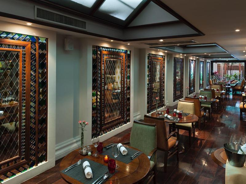 Elegantes Restaurant mit Holzmöbeln, bunter Dekoration und gedämpftem Licht.