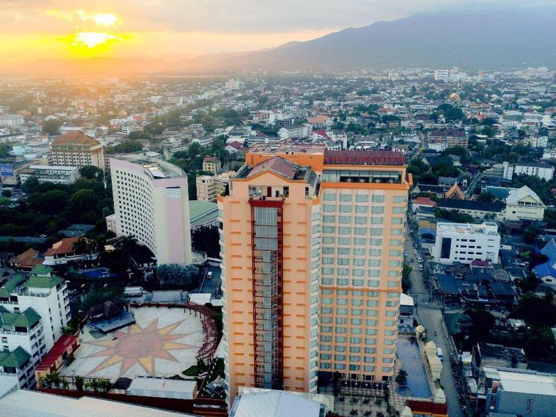 Stadtansicht bei Sonnenuntergang mit hohen Gebäuden und Bergen im Hintergrund