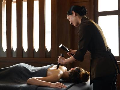 Eine Frau erhält eine entspannende Massage in einem ruhigen Spa mit warmem Licht.