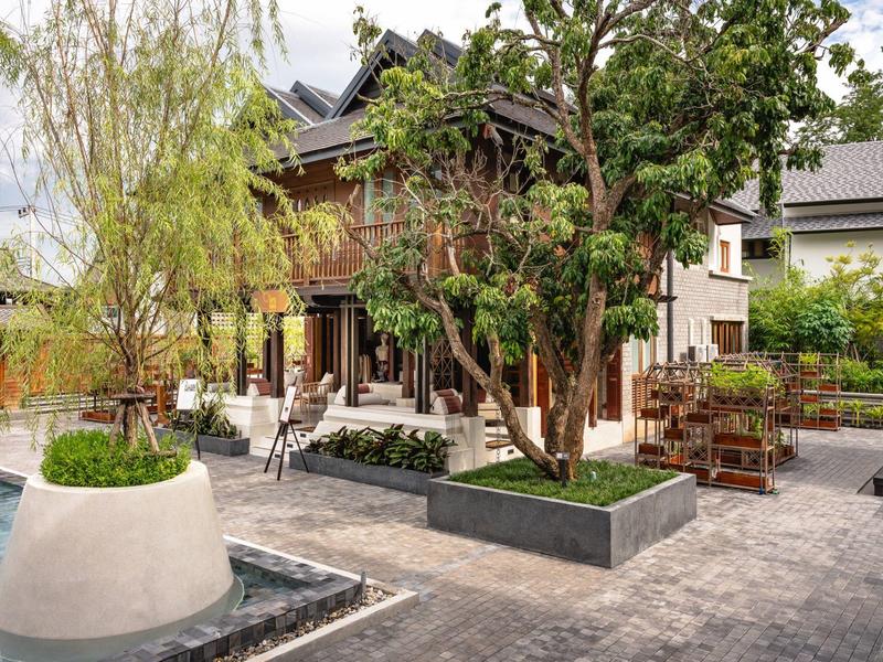 Moderner Hotelgarten mit Sitzgelegenheiten und üppiger Bepflanzung in einem ruhigen Innenhof.