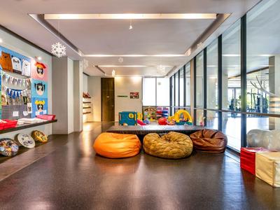 Moderne Hotel-Lounge mit bunten Sitzsäcken und großen Fenstern