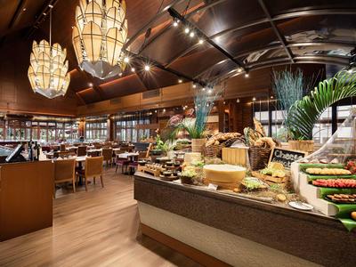 Elegantes Hotelrestaurant mit Buffet und warmem Holzboden unter stilvoller Beleuchtung.