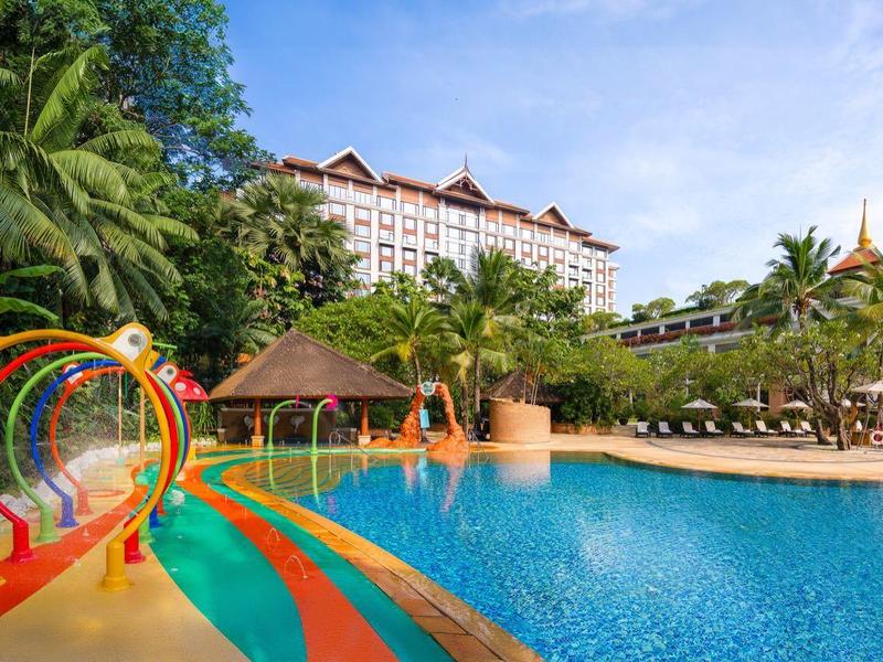 Großer Hotelpool mit Wasserrutschen und Palmen an einem sonnigen Tag