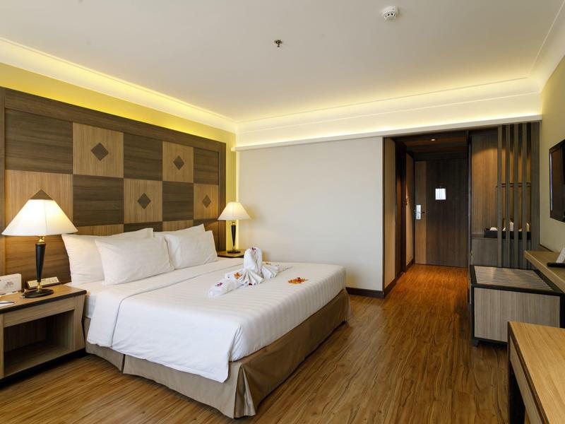 Modern ausgestattetes Hotelzimmer mit großem Doppelbett und Holzboden.