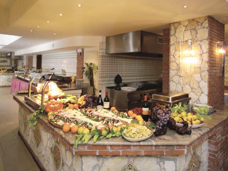 Buffet mit verschiedenen Obstsorten und dekorativ angerichteten Speisen in gemütlicher Raumumgebung.