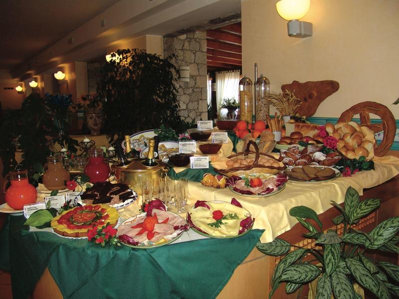 Buffet mit vielfältigem Frühstück: Gebäck, Obst, Käse, Wurst und Getränke auf gedecktem Tisch.