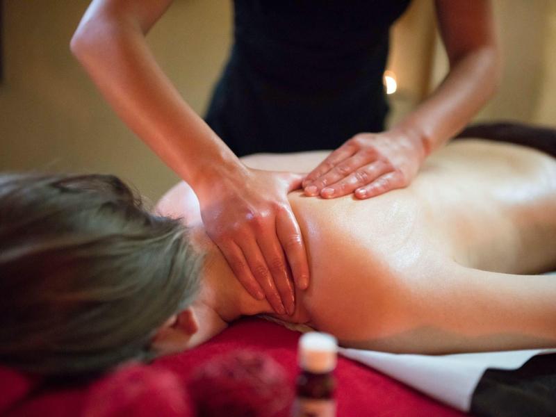 Iemand krijgt een rugmassage in een ontspannende spa-omgeving.